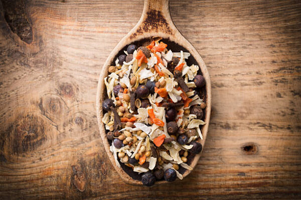 Spice mix a wooden spoon on a wooden background.